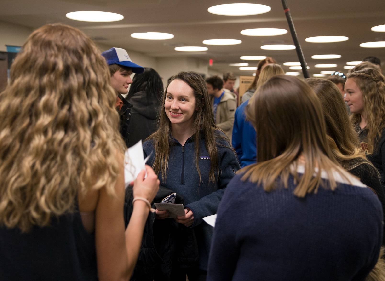 Student smiling while talking to a group at campus life night